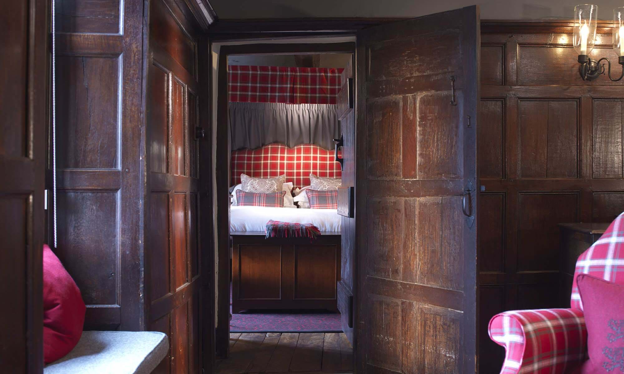 A classic four-poster bed with plaid details and warm lighting.