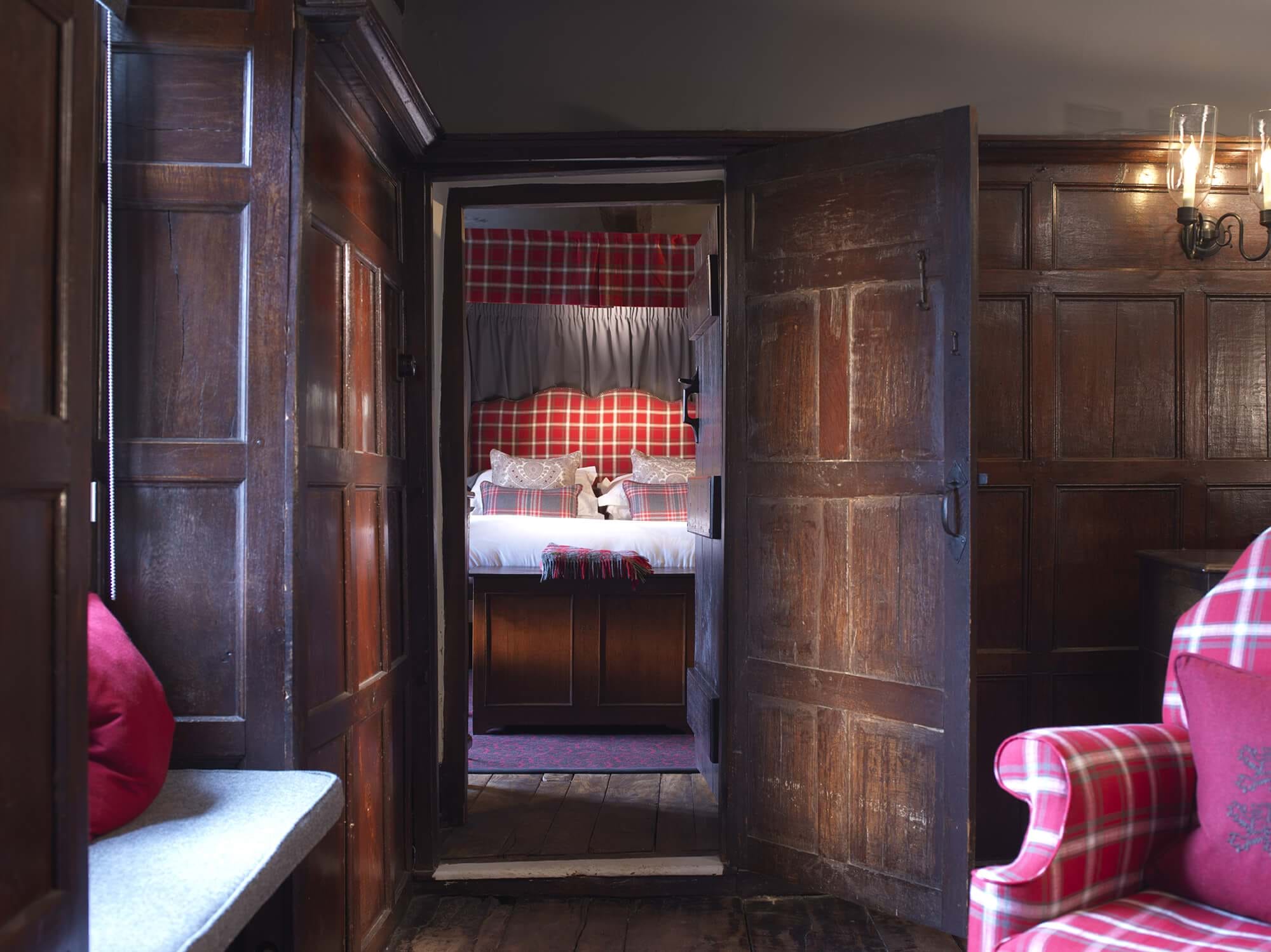 A classic four-poster bed with plaid details and warm lighting.