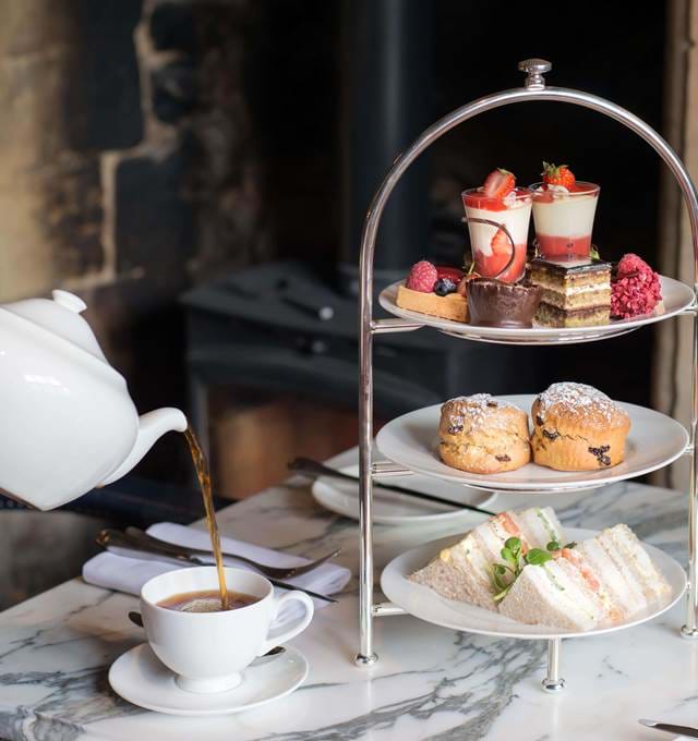 Three-tiered afternoon tea at The Lygon Arms, with seasonal finger sandwiches, scones and sweet options; served with a variety of teas.