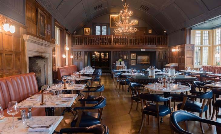 Elegant restaurant with leather seating, marble tables, and large windows.