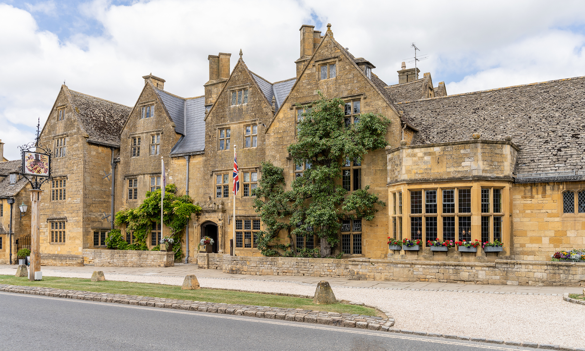 Historic stone building with pitched roofs and flag.