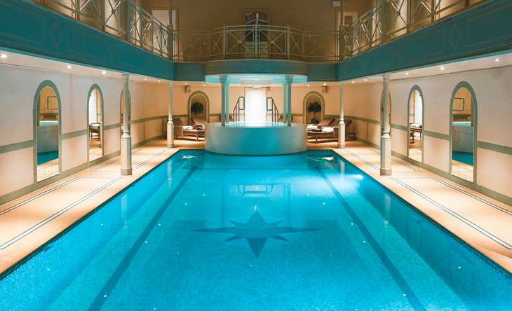 Indoor swimming pool with lounge chairs.