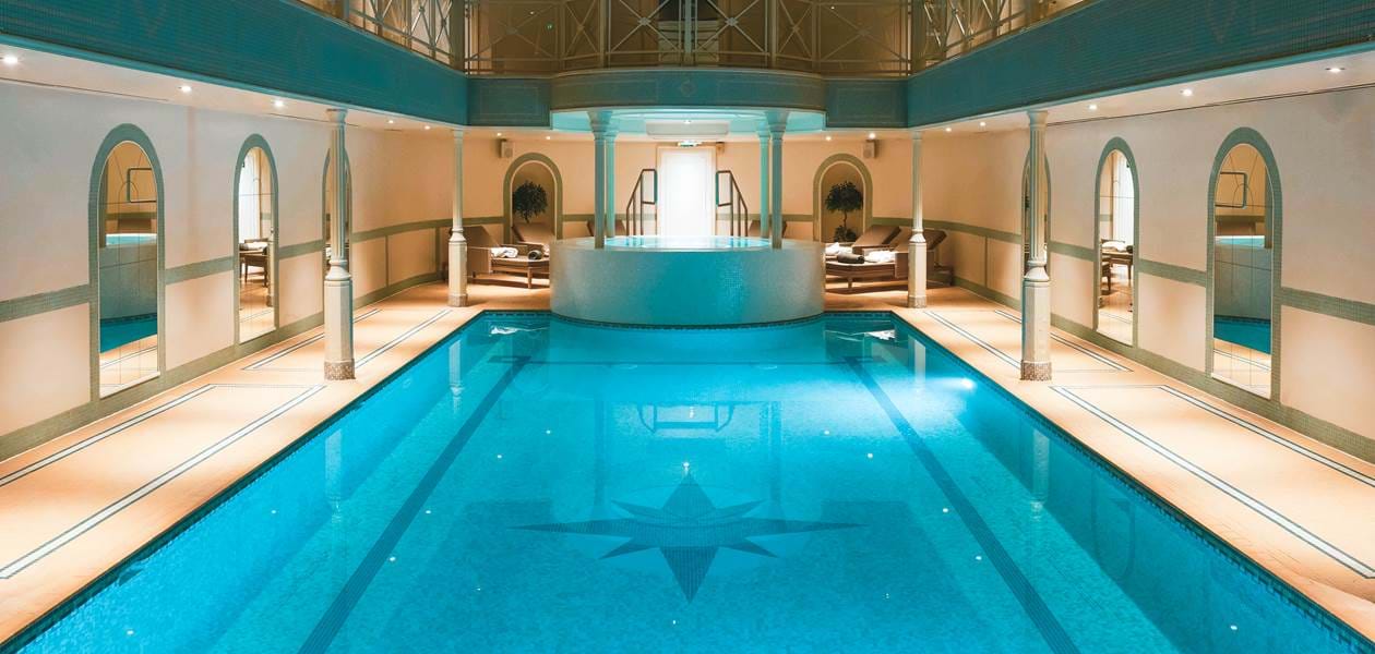 Indoor swimming pool with lounge chairs.