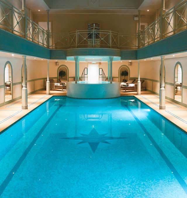 Indoor swimming pool with lounge chairs.
