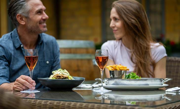 Couple having a meal in the outdoor seating area at the Grill restaurant