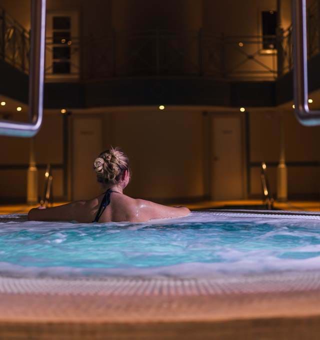 Woman In Jacuzzi Looking Out To Pool