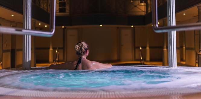 Woman In Jacuzzi Looking Out To Pool