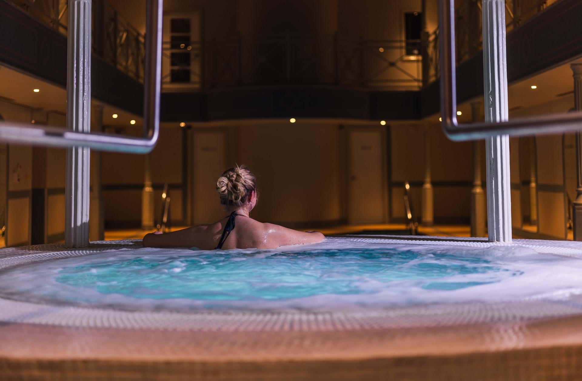 Woman In Jacuzzi Looking Out To Pool