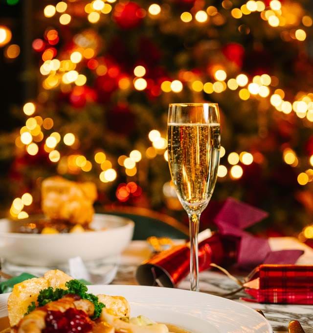 Festive food and glass of champagne in front of a Christmas tree