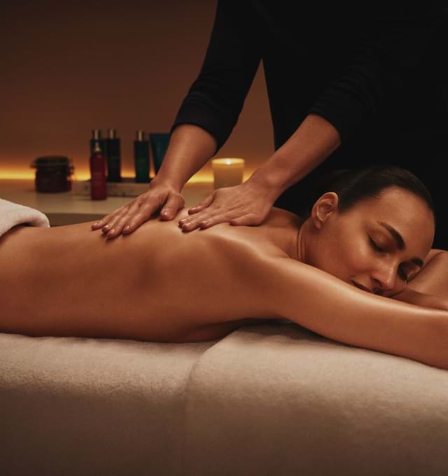 Therapist providing a back massage to a guest