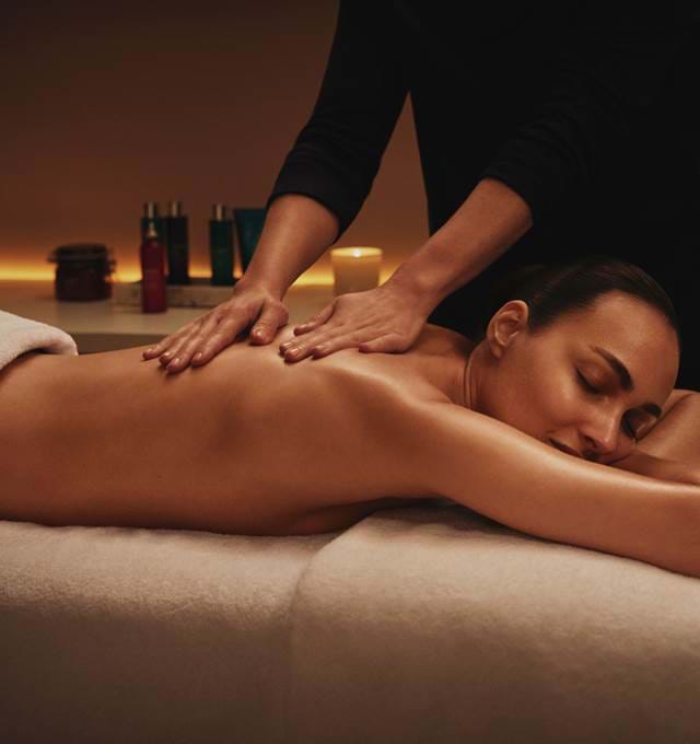 Therapist providing a back massage to a guest