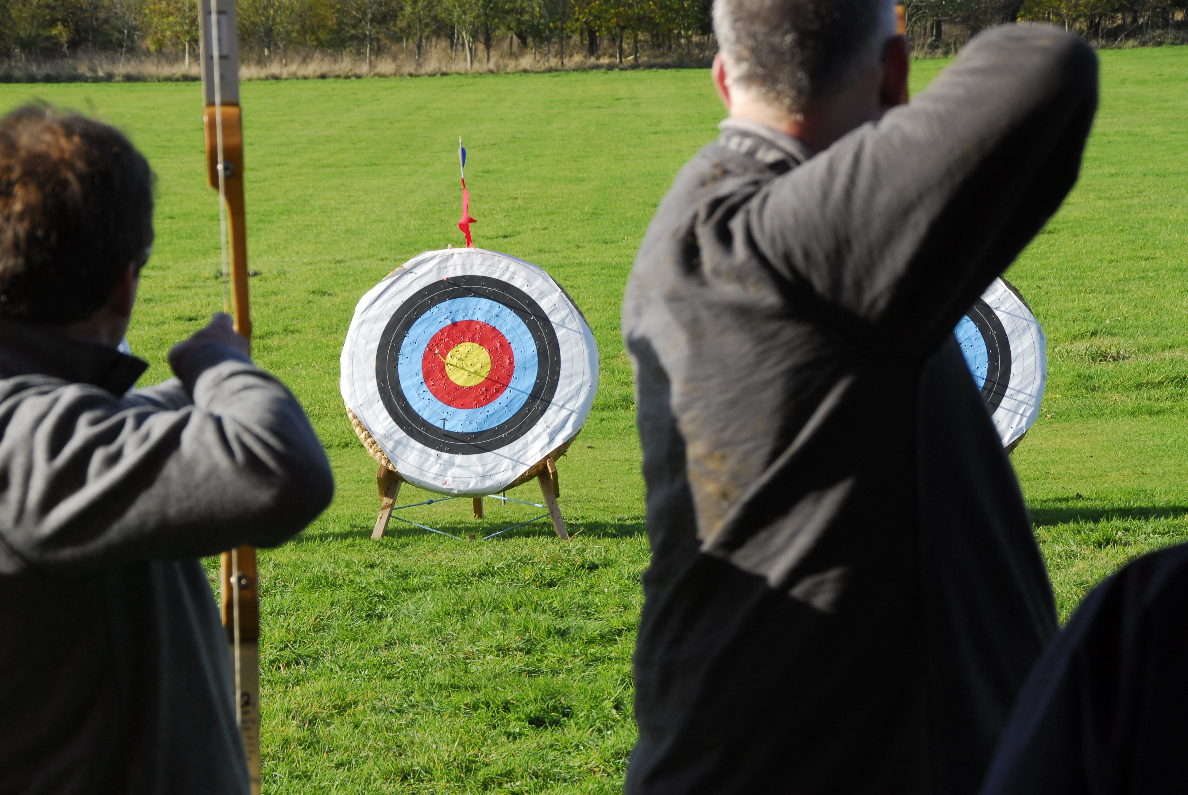 People practicing archery outdoors