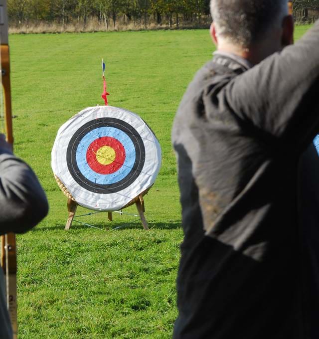 People practicing archery outdoors